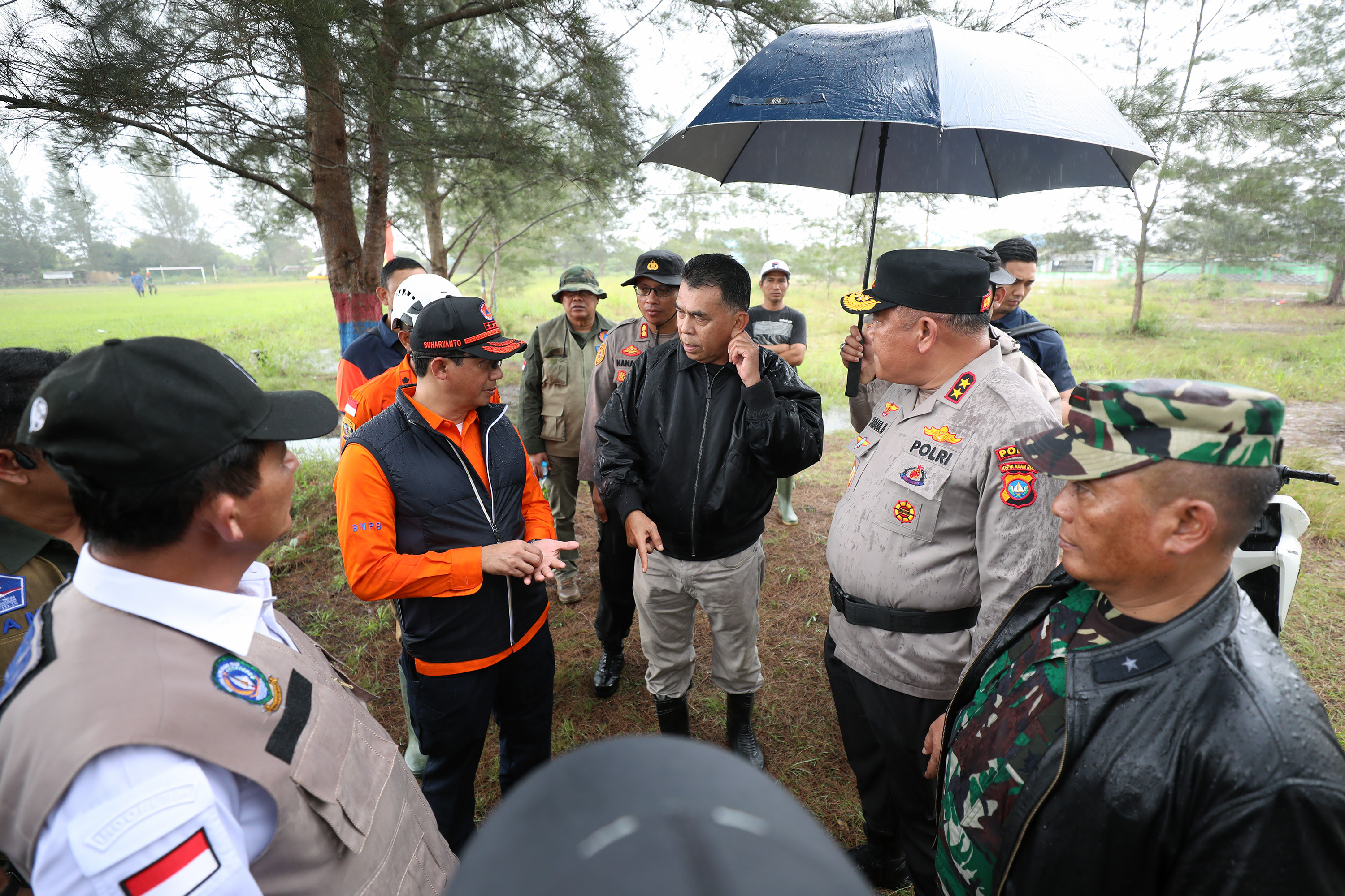 Kepala BNPB Letjen TNI Suharyanto (kemeja oranye berompi hitam) memberikan arahan kepada Pemda Natuna mendarat di lapangan Desa Pangkalan, Kecamatan Serasan, Kabupaten Natuna, Kepulauan Riau, Rabu (8/3).